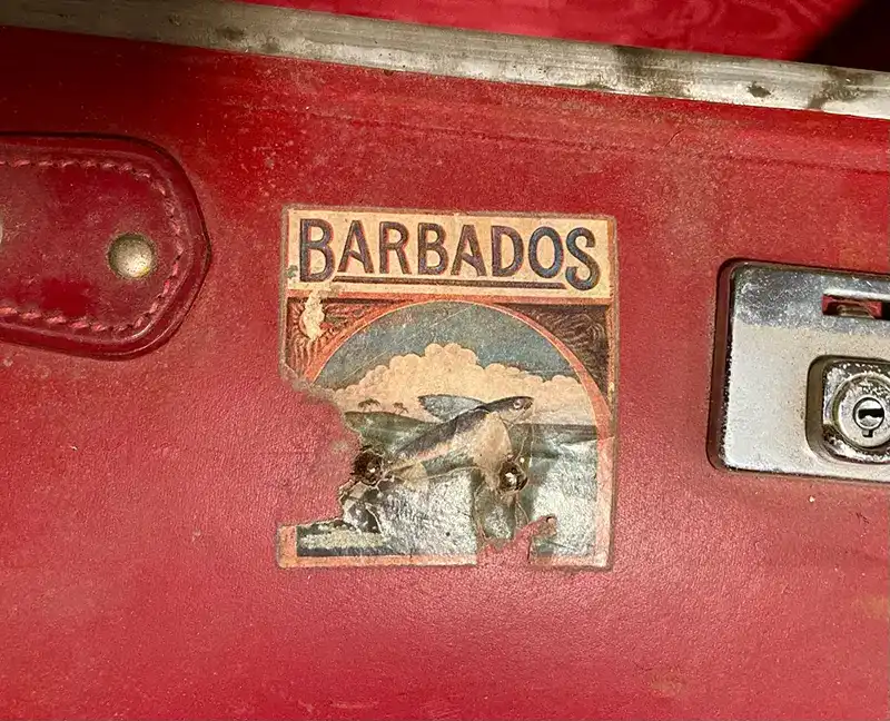 Barbados land of the flying fish luggage sticker on red suitcase